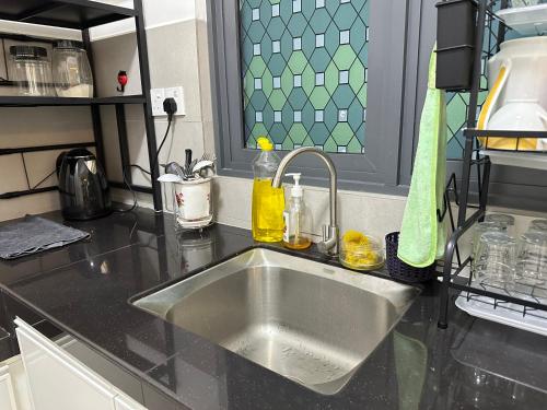 北赖Holiday Inn Stay 3B2R Meritus Residensi Perai的厨房柜台配有不锈钢水槽