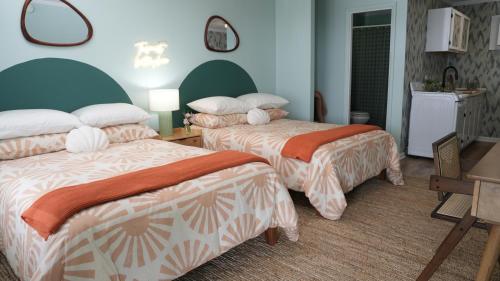 卡罗来纳比奇The Savannah Inn的酒店客房设有两张床和一张桌子。