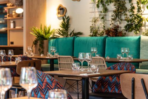 杜萨尔L'Arcalod Hôtel Restaurant & Spa的餐厅设有木桌和椅子,配酒杯