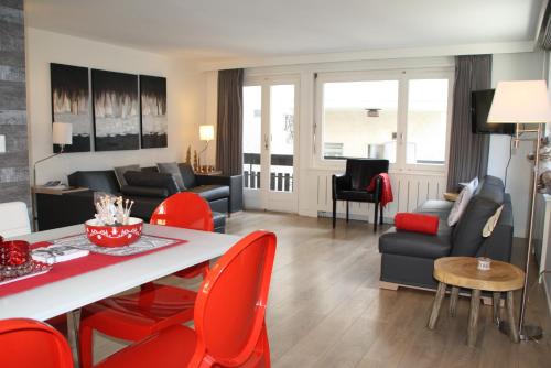 采尔马特Central & Elegant Apartments,partially with Fireplace, by Zermatt Rental的客厅配有桌子和红色椅子