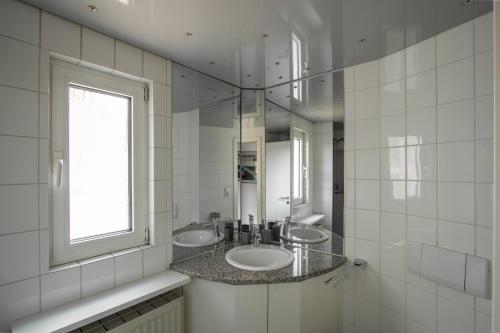 沃尔姆斯Penthouse-Maisonette - City Center, Highspeed Internet, Garage的白色的浴室设有两个盥洗盆和窗户。