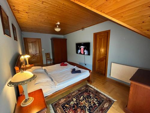巴拉顿博格拉尔Klára Villa的一间卧室设有一张带木制天花板的大床
