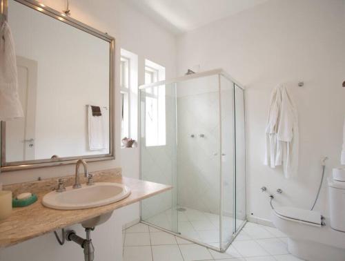 圣保罗Charmosa casa 4 suítes no Jd Europa的一间带玻璃淋浴和水槽的浴室