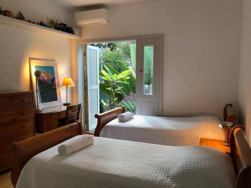 圣保罗Charmosa casa 4 suítes no Jd Europa的一间卧室设有两张床和一个美景窗户。