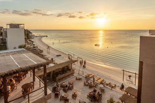 奥尔沃克斯岛AWA Holbox Hotel Boutique - Beach Front的享有日落海滩美景的大楼