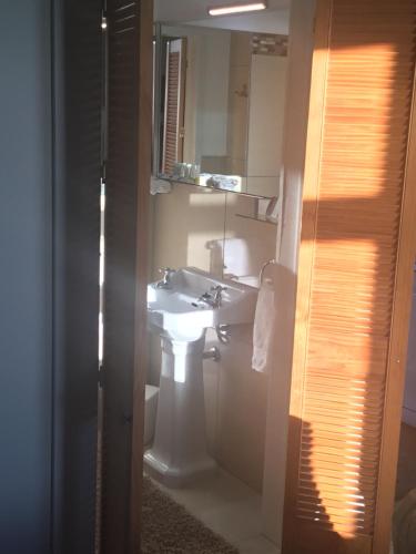 LawrenceTonix Boutique Accommodation的浴室设有白色水槽和镜子