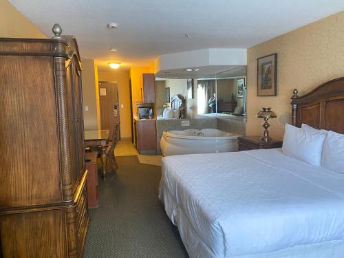 麦克默里堡优异套房酒店 的一间卧室配有一张床,浴室设有浴缸