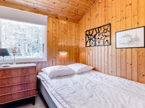 斯特兰比Holiday home Strandby XIII的卧室配有木墙内的一张床
