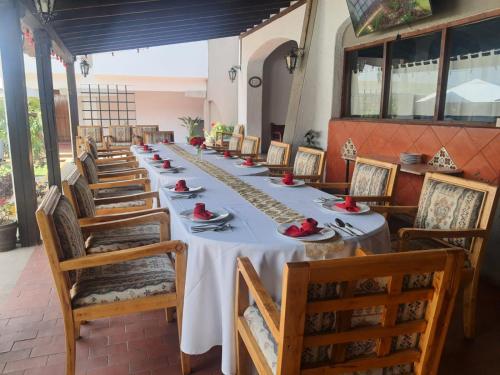 乔卢拉乔卢拉考古别墅酒店的长长的用餐室配有长桌子和椅子
