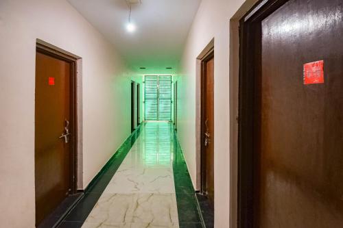 瓜廖尔SPOT ON 66974 Hotel shri gurukripa的走廊上设有绿色地板和长长的走廊