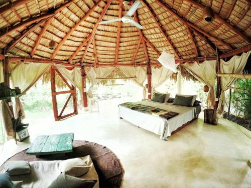 拉斯特拉纳斯Dream Glamping Jungle Bohio的帐篷内一间卧室,配有一张床和一张沙发