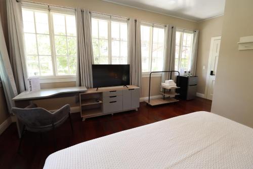 巴拿马城Casa Randa的一间卧室配有一张床、一张书桌和一台电视