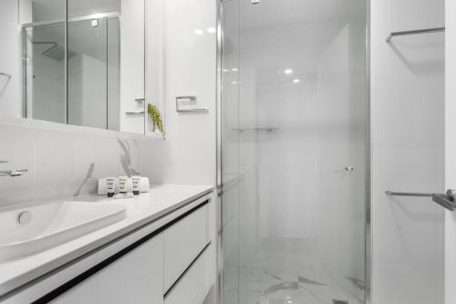 堪培拉Central Canberra 2-Bed with Gym & BBQ Area的带淋浴和盥洗盆的白色浴室