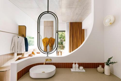 拜伦湾Basq House的一间带圆形镜子和水槽的浴室