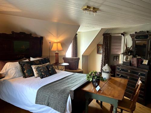 比克Le Mange Grenouille的一间卧室配有一张床、一张桌子和一张书桌