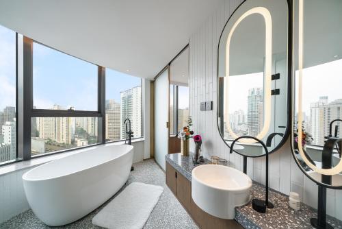上海上海徐家汇A.T.HOUSE酒店的浴室配有大型白色浴缸和水槽