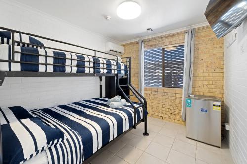 卡伦德拉Motel Sunshine Coast的一间卧室设有两张双层床和一扇窗户。