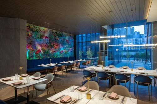 合肥合肥滨湖voco酒店的餐厅设有桌椅和大窗户。