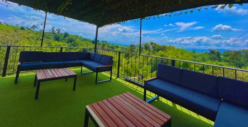 金巴亚Hotel Campestre Atardecer Cafetero的阳台上的2个蓝色长椅享有美景
