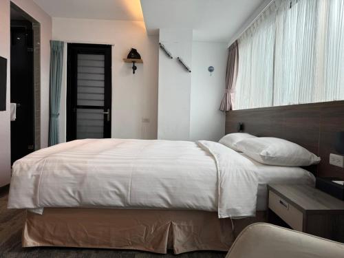 台北RF富裕自由旅店 - 林森馆的卧室设有一张白色大床和一扇窗户。