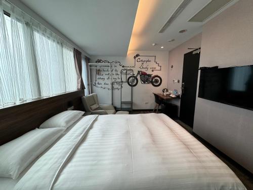 台北RF富裕自由旅店 - 林森馆的一间卧室配有一张大床和电视