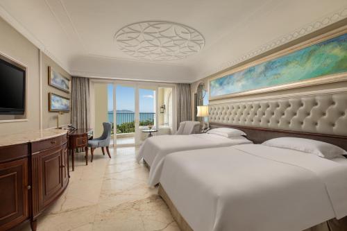 三亚三亚湾皇冠假日度假酒店（巴洛克C位一线海景）的酒店客房设有两张床和电视。