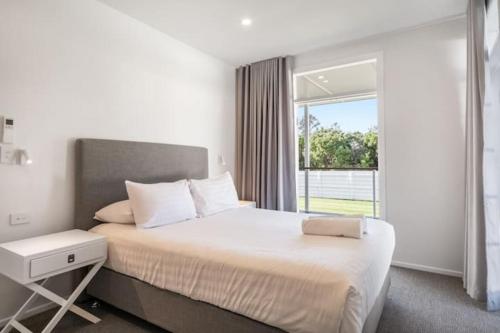 拜伦湾Exquisite 5-Bedroom Coastal Haven in Byron Bay的一间卧室设有一张大床和一个窗户。
