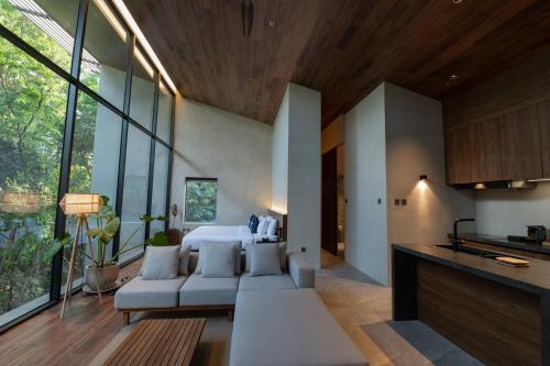 爱妮岛Piece Lio Resort from Japan的带沙发的客厅和带窗户的厨房