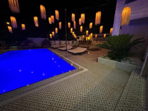 安塔利亚GÜLER BUTİK HOTEL的夜间在院子里的游泳池,灯光照亮