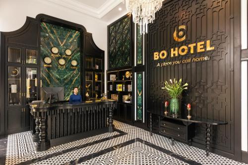 海阳BO Hotel的奢华的酒店大堂,有一位男士坐在书桌上