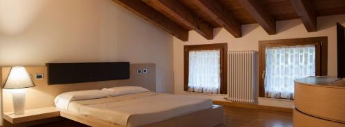 维琴察Albergo Torre的一间卧室配有一张床和一台平面电视