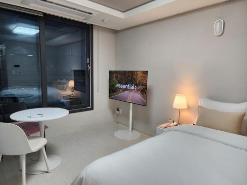 大邱동성로 Residence Daon的一间卧室配有一张床、一台电视和一张桌子