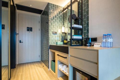 珠海珠海横琴雅辰悦居酒店的浴室设有水槽和带瓶子的台面。