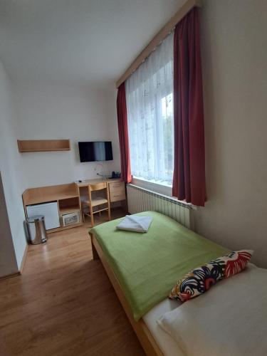 布拉格加尼酒店拉米伯塞克酒店的一间卧室设有一张绿色的床和一个窗户。