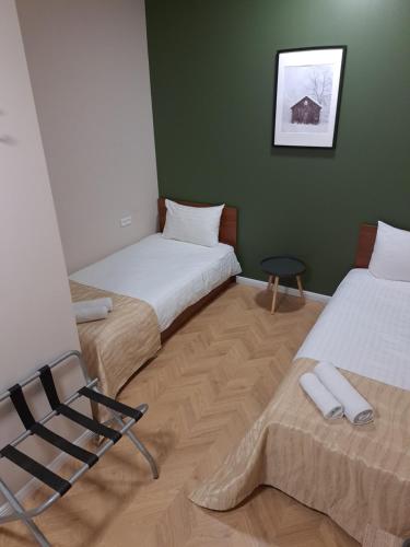 希奥利艾Pušelė的两张睡床彼此相邻,位于一个房间里