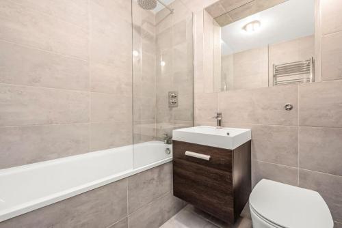 伦敦Queens Park Vibrant 1BR Flat with Balcony的浴室配有卫生间、盥洗盆和浴缸。