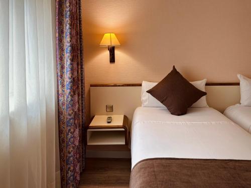 安道尔城安道​​尔宫酒店的酒店客房配有一张床和一张带台灯的桌子