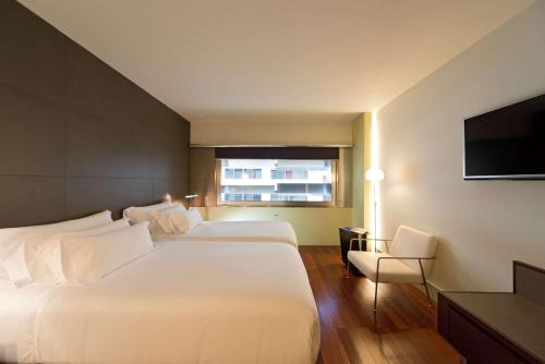巴塞罗那NH巴塞罗那康斯坦萨酒店的酒店客房设有两张床和一台平面电视。