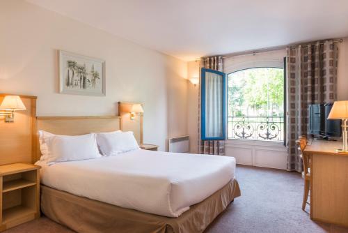 勒普莱西罗班松格朗德公寓大酒店的一间设有大床和窗户的酒店客房