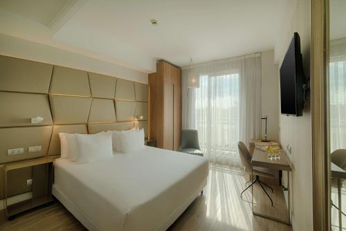 罗马罗马中心NH酒店的卧室设有一张白色大床和一扇窗户。