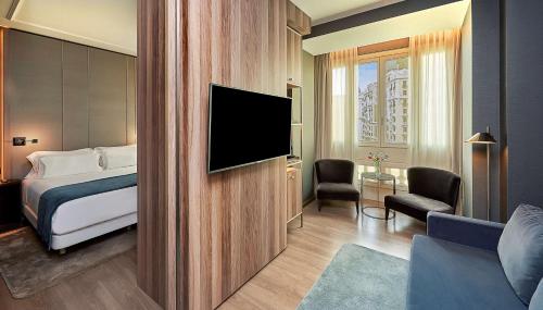 马德里马德里格兰大街乔利酒店的配有一张床和一台平面电视的酒店客房