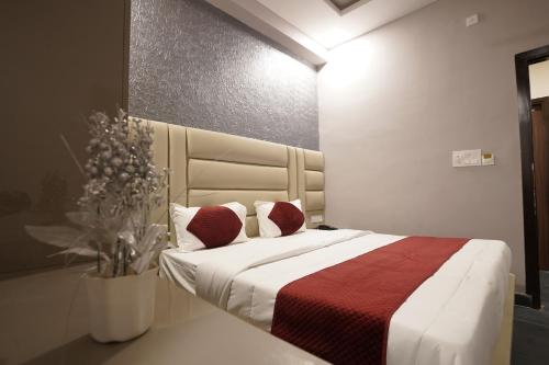 斋浦尔The Connaught House Jaipur的一间卧室配有一张带红色和白色枕头的大床