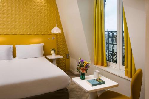 巴黎NH Paris Gare de l'Est的一间卧室设有床和黄色窗帘的窗户
