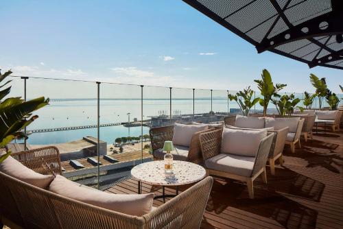 里斯本Tivoli Oriente Lisboa Hotel的一个带桌椅的海景庭院