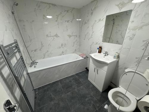伯恩茅斯A&K Inn的浴室配有卫生间、浴缸和水槽。