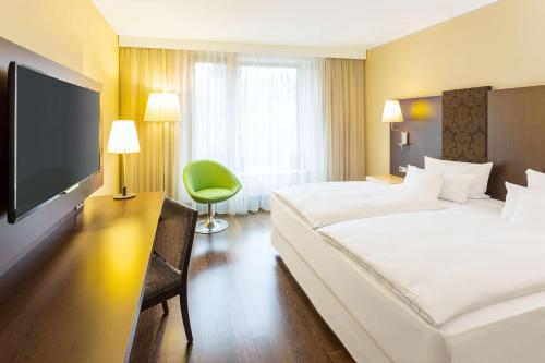 德累斯顿德累斯顿阿尔特马尔克特NH酒店集团的一间酒店客房,配有一张大床和一台平面电视