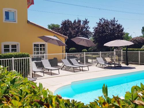马诺斯克宜必思马诺斯克卡达拉切酒店的房屋旁的游泳池配有椅子和遮阳伞