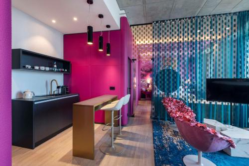 美因河畔法兰克福nhow Frankfurt的厨房设有粉红色和紫色的墙壁和酒吧