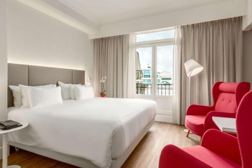 布鲁塞尔布鲁塞尔中心酒店的酒店客房,配有一张床和一张红色椅子