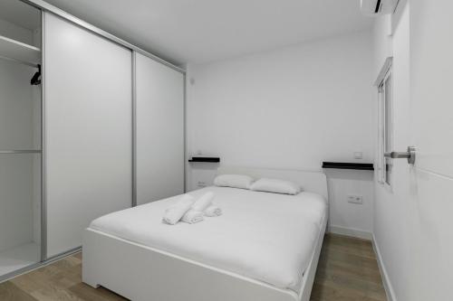马德里GuestReady - Ideal Stay in Vibrant Ciudad Lineal的白色客房,配有带毛巾的床